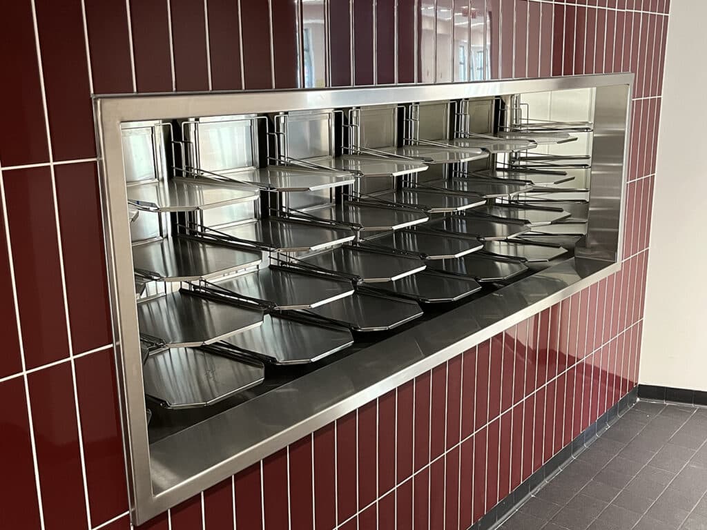 solid dish accumulator system built into a red tile wall